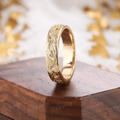 a gold wedding ring sitting on top of a wooden box