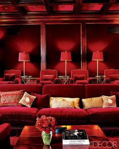 a living room filled with red couches and lamps on top of each other's sides