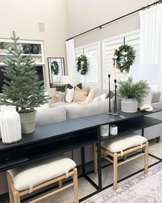 a living room filled with furniture and a christmas tree on top of a black table