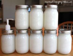 four jars with soap and lotion sitting on a table