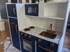 a kitchen with blue cabinets and white counter tops