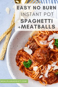 spaghetti with meatballs and parmesan cheese on the side in a white bowl