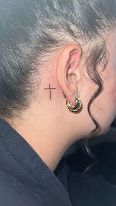 a woman with a cross behind her ear