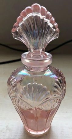 a pink glass vase sitting on top of a table