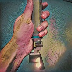 a hand holding a flashlight in front of a blue and green background with the light shining on it