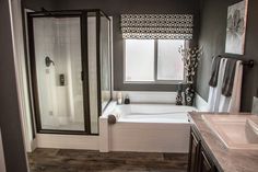 a bathroom with a sink, shower and bathtub next to a window in it