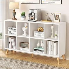 a white book shelf with books and pictures on it