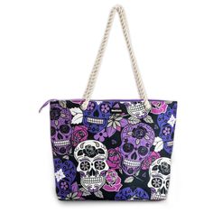 a handbag with skulls and flowers on the front, hanging from a white rope