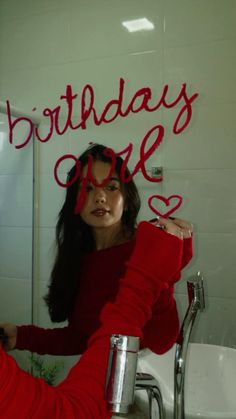 a woman sitting in front of a bathroom mirror with the words birthday love written on it