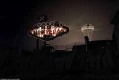 an old neon sign is lit up in the dark at night with lights on it