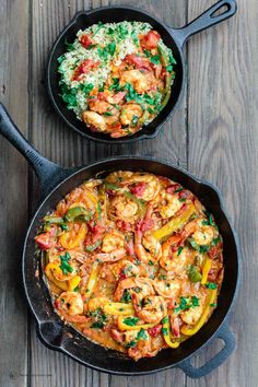 two skillets filled with shrimp and vegetables on top of a wooden table next to rice