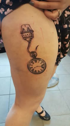 a woman with a clock tattoo on her thigh