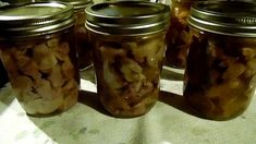 four jars filled with food sitting on top of a table