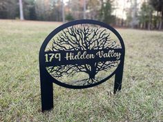 a metal sign that reads 74 hidden valley with a tree on it in the grass