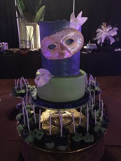 a three tiered cake with an owl on it's face and purple icing