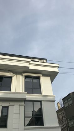 an apartment building with two windows on the top floor and one window in the middle