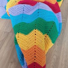 there is a crocheted blanket that looks like a giraffe with many colors on it