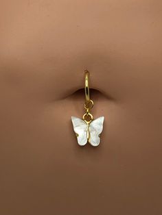 the butterfly charm is attached to a gold plated ring with a white flower on it