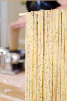 a close up of some food on a wooden table with a person in the background