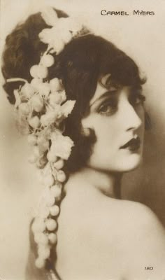 an old photo of a woman with flowers in her hair