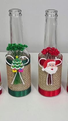 three glass bottles decorated with christmas decorations