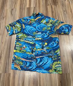 The shirt is in excellent condition with no flaws to note. Its marked a large but fits more like a medium. It has a nice look and feel and the graphics are great. Please look over all the pics for measurements and condition and let me know if you have any questions!  We ship one or two days after receiving payment for purchases. Returns are not accepted. Thanks for dropping by. We're glad you found us! Retro Long Sleeve Beach Shirt, Retro Long Sleeve Shirt For Beach, Retro Collared Short Sleeve Shirt With Graphic Print, Cotton Hawaiian Shirt With Retro Print And Camp Collar, Blue Retro Hawaiian Shirt With Graphic Print, Vintage Blue Graphic Print Camp Shirt, Vintage Blue Camp Shirt With Graphic Print, Retro Blue Camp Shirt With Graphic Print, Retro Button-up Hawaiian Shirt