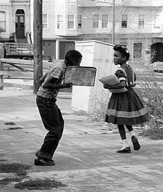 an old photo of two children playing on the sidewalk