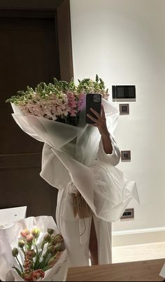 a woman taking a selfie while holding flowers