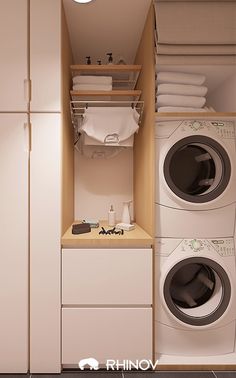 a washer and dryer in a small room with white cabinets on the wall