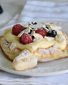 a pastry topped with fruit and powdered sugar