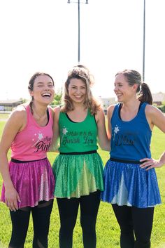 three girls standing next to each other on a field