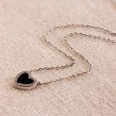 Rock our Pave Onyx Heart Necklace any time, any day! With a trendy heart shaped charm and glittering Pave CZ Diamonds surround it, this charm necklace is perfect as a standout piece to wear alone, yet also layers beautifully with other jewelry you may have. SKU: RR-NR211 Product Details Material: High Quality Solid 925 Sterling Silver Finish: 18K Gold ∙ Sterling Silver Featuring a ~10x9.5mm Onyx Heart Pendant with ~1mm surrounding Pave Diamonds on an adjustable 15 to 17 inch chain Featured Style Domed Ring, Cz Diamond, Birthstone Ring, Heart Pendant Necklace, Pave Diamonds, Solid 925 Sterling Silver, Heart Necklace, Chain Bracelet, Heart Pendant