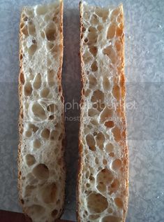 two pieces of bread sitting on top of a counter next to each other with holes in them