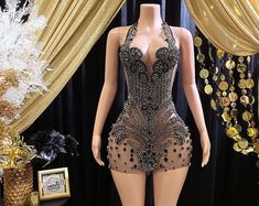 a mannequin is dressed in a black and gold dress with sequins