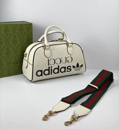 Part of the adidas x Gucci collection, this mini duffle bag features the 'Gucci adidas' and Trefoil print. adidas and Gucci venture into a collection, where the Web juxtaposes with the three white stripes, and the GG monogram combines with the trefoil. Pulling inspiration from the Creative Director’s memories of the '80s and '90s, emblematic House’s motifs mix with those of the historic sportswear brand adidas resulting in a series of hybrid looks.es. Gucci X Adidas Bag, Gucci Adidas Bags, Gucci Adidas Bag, Duffle Bag Aesthetic, Adidas Duffle Bag, Adidas X Gucci, Gucci X Adidas, Adidas Bag, Gg Collection