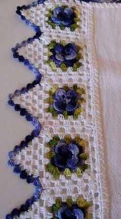 an embroidered table runner with blue flowers on it