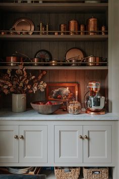 a kitchen cupboard filled with lots of pots and pans on top of wooden shelves