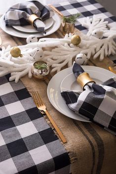 the table is set with black and white plaid napkins, silverware, and gold accents