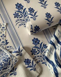 blue and white wallpaper with floral designs on the sides, including one large piece of cloth