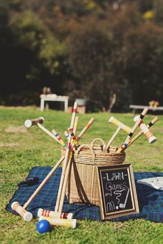 a basket filled with croquets sitting on top of a grass covered field