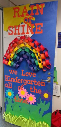 a door decorated with rainbows and the words rain or shine, we love kindergarten all of the colors