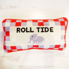 a red and white pillow with the word roll tide on it