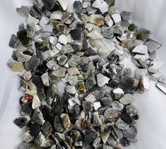 a pile of rocks sitting on top of a white table next to a pair of scissors