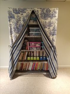 a bookshelf made out of an old bookcase with curtains over the top