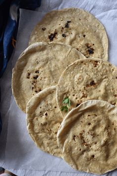 four tortillas sitting on top of a white napkin