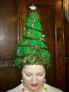 a woman wearing a green christmas tree hat