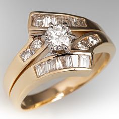 an engagement ring set with two bands and a round diamond center surrounded by baguettes