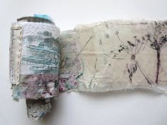 a roll of torn fabric sitting on top of a white wall