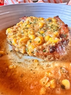 a piece of meat covered in corn on top of broth