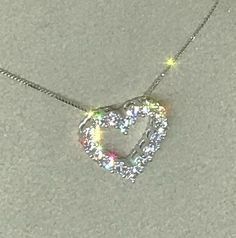 a diamond heart necklace on a chain with sparkles in the middle and an opening at the end